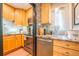 Well-lit kitchen with wood cabinets, granite countertops, stainless steel appliances, and stylish backsplash at 1365 N Corona St # 11, Denver, CO 80218