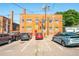 View of the parking lot featuring multiple parked cars in front of a brick apartment building at 1365 N Corona St # 11, Denver, CO 80218
