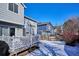 Snowy backyard with a deck and neighboring houses at 8716 Starwood Ln, Parker, CO 80134