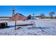 Red barn with windmill and farm equipment in winter at 8716 Starwood Ln, Parker, CO 80134