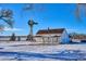 White farmhouse with windmill on snowy landscape at 8716 Starwood Ln, Parker, CO 80134