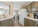 Modern kitchen with white appliances and view into dining area at 8716 Starwood Ln, Parker, CO 80134