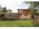 Spacious backyard with lush green grass, mature trees, and a patio area for entertaining at 365 Seminole Dr, Boulder, CO 80303
