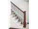 Elegant staircase features carpeted steps, wood handrail, and wrought iron balusters at 365 Seminole Dr, Boulder, CO 80303