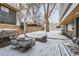 Covered patio and firepit in a snowy backyard at 3915 W Byron Pl, Denver, CO 80212
