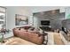 Modern living room with leather sectional and a brick accent wall at 3915 W Byron Pl, Denver, CO 80212