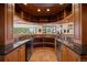 Wet bar with granite countertop, wood cabinetry, and curved design at 606 Cliffgate Ln, Castle Rock, CO 80108