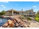 Luxurious home features an inviting patio with a stone fire pit and waterfall spilling into the dazzling pool at 606 Cliffgate Ln, Castle Rock, CO 80108