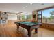 Spacious game room with a pool table, fireplace, hardwood floors, and large windows with a great view at 606 Cliffgate Ln, Castle Rock, CO 80108