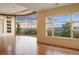 Bright living room with hardwood floors and a curved wall of windows with a stunning mountain view at 606 Cliffgate Ln, Castle Rock, CO 80108