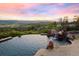 Relaxing infinity pool overlooks serene landscape with lush trees and dramatic rock features with mountain sunset views at 606 Cliffgate Ln, Castle Rock, CO 80108