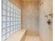 Walk-in shower featuring glass block accents and a built-in bench, offering a spa-like experience at 606 Cliffgate Ln, Castle Rock, CO 80108