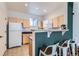 Eat-in kitchen bar area with adjacent white appliances, light wood cabinets, and stylish stools at 85 Uinta Way # 702, Denver, CO 80230
