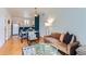 Inviting living room with hardwood floors, stylish furnishings, and a view of the adjacent dining area and kitchen at 85 Uinta Way # 702, Denver, CO 80230