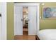 Bedroom with sliding doors, neutral green walls, and view into living room at 1301 N Ogden St # 1A, Denver, CO 80218