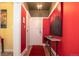 Bright hallway with vibrant red walls, decorative art, and a hardwood floor leading to other rooms at 1301 N Ogden St # 1A, Denver, CO 80218