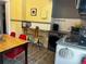 Eclectic kitchen with gas range, wood floors, dining table with red chairs, and breakfast bar at 1301 N Ogden St # 1A, Denver, CO 80218