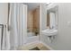 Well-lit bathroom featuring a shower and bathtub with tile walls and safety bars plus a white sink and mirror at 7240 W Custer Ave # 119, Lakewood, CO 80226