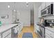 Well-lit kitchen with stainless steel appliances, ample counter space, and a blue patterned rug at 7240 W Custer Ave # 119, Lakewood, CO 80226