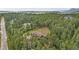 Aerial view of a multi-story home surrounded by mature trees and lush landscaping at 14271 Timber Trl, Larkspur, CO 80118