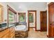 Bathroom with custom wood cabinets, stone accents, soaking tub and windows with natural light at 14271 Timber Trl, Larkspur, CO 80118