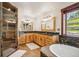 Luxurious bathroom with a soaking tub, walk-in shower, and stone accents at 14271 Timber Trl, Larkspur, CO 80118