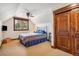 Comfortable bedroom with a plaid comforter, and natural light from the window with forest view at 14271 Timber Trl, Larkspur, CO 80118