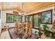 Bright dining area with rustic wood furniture, stylish chandelier, hardwood floors and scenic views at 14271 Timber Trl, Larkspur, CO 80118