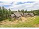 Exterior featuring a multi-story home with an attached deck surrounded by mature trees on a hillside at 14271 Timber Trl, Larkspur, CO 80118