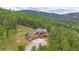 Picture-perfect exterior featuring lush landscaping, mountain views, and gorgeous architectural details at 14271 Timber Trl, Larkspur, CO 80118