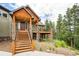 Front entrance featuring natural wood stairs and stone support beams at 14271 Timber Trl, Larkspur, CO 80118