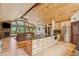 Living room and kitchen combo with views of the outdoors, hardwood flooring and stone fireplace feature at 14271 Timber Trl, Larkspur, CO 80118