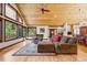 Open-concept living area with hardwood floors, wood ceilings, large windows with views, and comfortable seating at 14271 Timber Trl, Larkspur, CO 80118