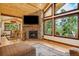Cozy living room with stone fireplace and views of the outdoors at 14271 Timber Trl, Larkspur, CO 80118