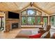 This living room offers natural light from large windows, a stacked stone fireplace and an open, airy feel at 14271 Timber Trl, Larkspur, CO 80118