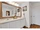 Bright bathroom features a double sink vanity, an oversized mirror, and decorative wall art at 1443 S Emporia Ct, Aurora, CO 80247