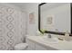 Well-lit bathroom with neutral tones, a shower with patterned curtain and a vanity with decorative accents at 1443 S Emporia Ct, Aurora, CO 80247