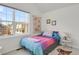 Sunlit bedroom featuring a large window, and whimsical decor creating a cozy atmosphere at 1443 S Emporia Ct, Aurora, CO 80247