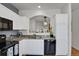 Kitchen featuring granite countertops, white cabinets, modern appliances and breakfast bar at 1443 S Emporia Ct, Aurora, CO 80247