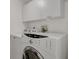 Well-equipped laundry room with a washer, dryer, and overhead cabinets for storage at 1443 S Emporia Ct, Aurora, CO 80247