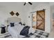 Bedroom with a sliding barn door leading to ensuite bathroom at 1443 S Emporia Ct, Aurora, CO 80247