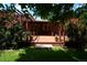 Charming backyard deck surrounded by lush greenery and blooming red roses, perfect for outdoor living at 8292 E Lehigh Dr, Denver, CO 80237