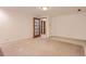 Spacious basement area with carpeting, neutral paint and an interior door with glass panes at 8292 E Lehigh Dr, Denver, CO 80237