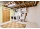 Functional basement laundry area with washer, dryer, and utility sink at 8292 E Lehigh Dr, Denver, CO 80237