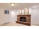 Basement featuring a brick fireplace, window and neutral colored walls and carpet at 8292 E Lehigh Dr, Denver, CO 80237