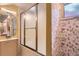 Cozy bathroom with a frosted glass shower door and floral wallpaper at 8292 E Lehigh Dr, Denver, CO 80237