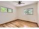 A bright, empty bedroom with hardwood floors, two windows, and a ceiling fan at 8292 E Lehigh Dr, Denver, CO 80237