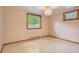 Bright bedroom with neutral walls, tile floor and a large window with green views at 8292 E Lehigh Dr, Denver, CO 80237
