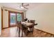 Cozy dining room featuring hardwood floors, a ceiling fan and a wood table set with flowers at 8292 E Lehigh Dr, Denver, CO 80237