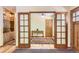 Entryway showing hardwood floors, built-in shelves, and doorway leading to a room with a wooden table at 8292 E Lehigh Dr, Denver, CO 80237